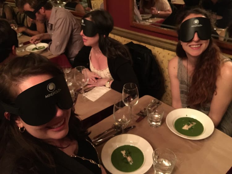 Michelle Della Giovanna from Full Time Explorer and her friend Kate smile for a photo that the waiter takes of them wearing their blindfolds