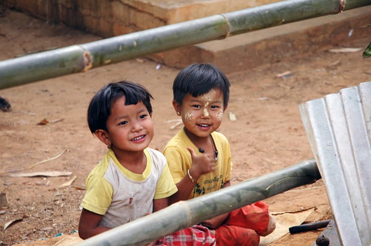 Two small Burmese kids giggle and laugh