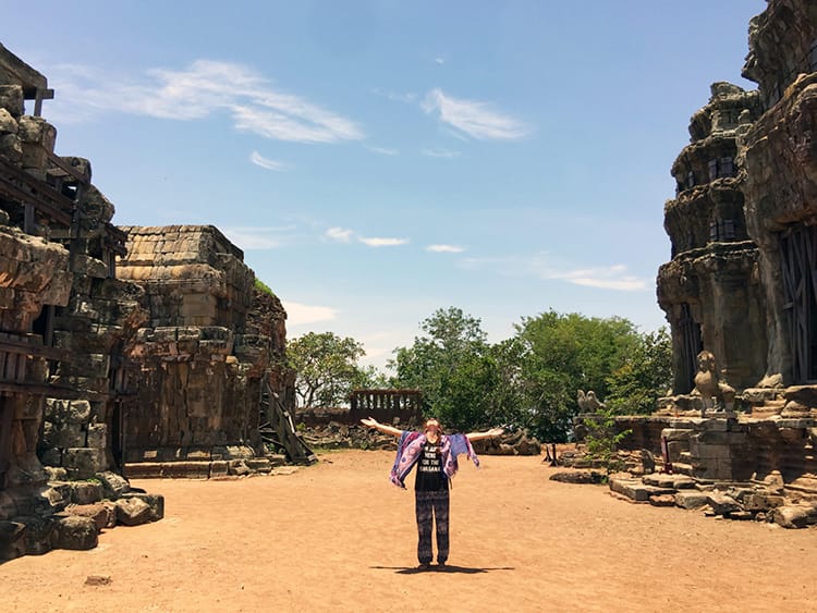 Michelle Della Giovanna from Full Time Explorer spins in a circle in the middle of ancient temples near Tonle Sap Lake in Siem Reap, Cambodia