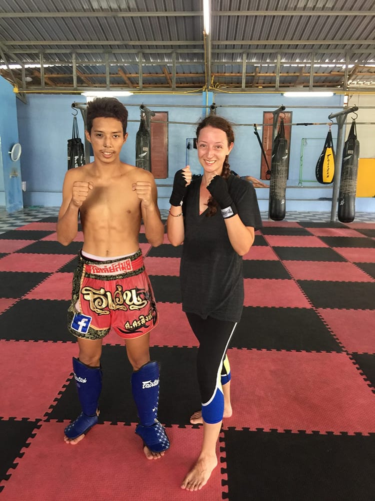 Michelle Della Giovanna from Full Time Explorer stands next to her coach during Muay Thai Classes in Thailand