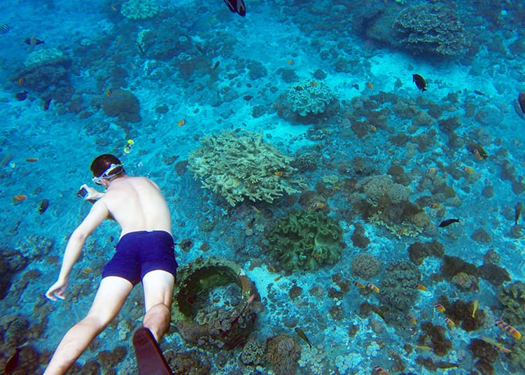 A man takes a photo while snorkeling in Nusa Lembongan