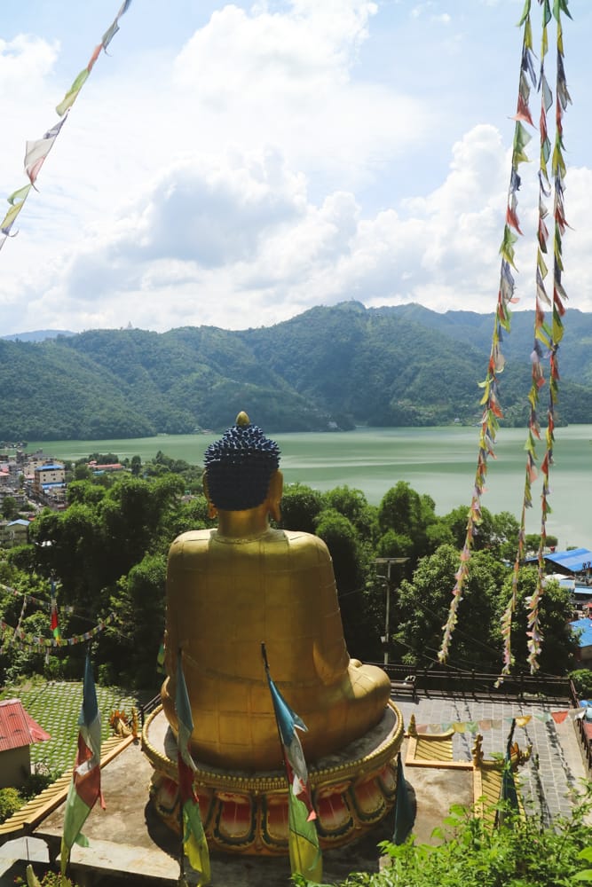 A giant gold Buddha statue at Pema Dechenling Monastery overlooks lakeside Pokhara - Places To Visit in Pokhara