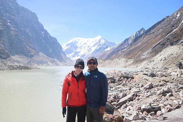 Michelle Della Giovanna from Full Time Explorer and Suraj Pradhan stand in front of Tsho Rolpa Lake