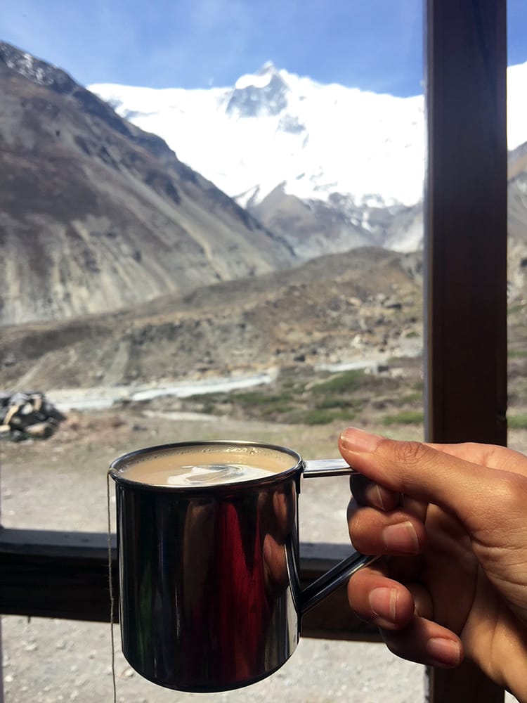 A cup of masala tea served in a metal cup in a teahouse near Tilicho Lake