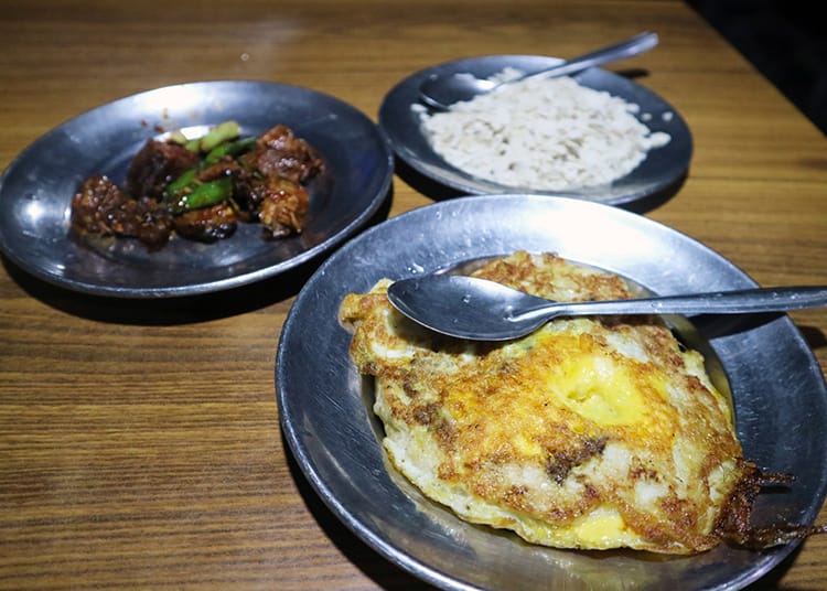 Local Newari food including bara, choila, and churra at Honacha restaurant in Patan