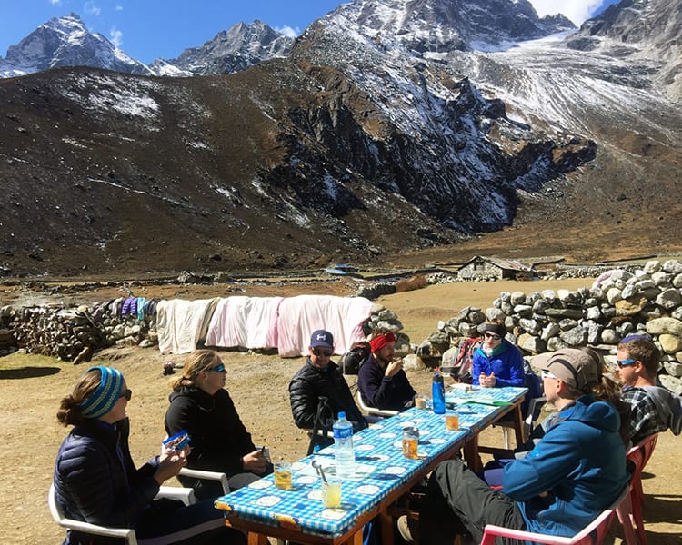 Trekkers having a tea break outside of a teahouse in Nepal