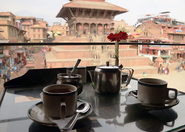Hot tea being served in a small old temple in Bhaktapur that looks out at one of the famous squares full of beautiful architecture
