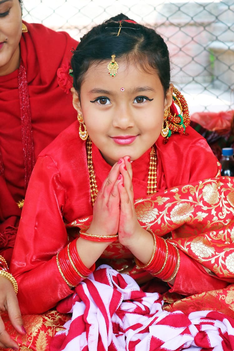 A Nepali girl says namaste during the Ehee ceremony