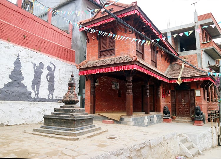 A small temple with a black and white mural of musicians in Kirtipur