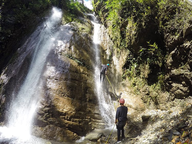 Michelle Della Giovanna from Full Time Explorer goes canyoning down a waterfall in Nepal