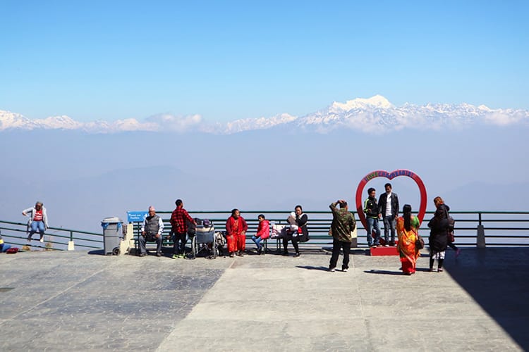 People stand in front of the viewpoint at Chandragiri Hills with a heart shaped sculpture
