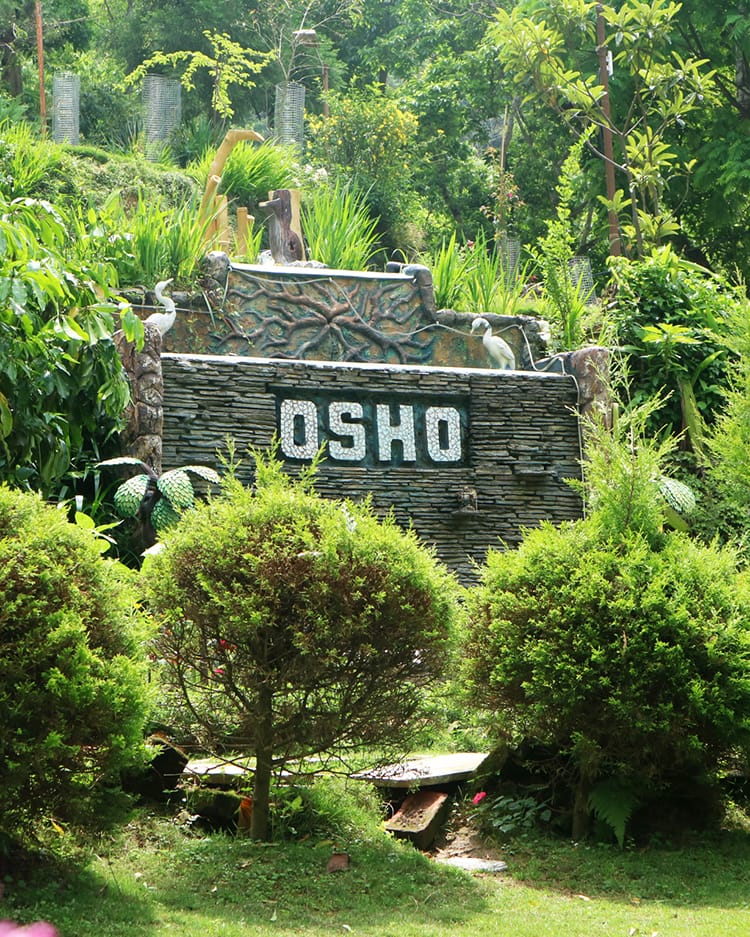 A manmade waterfall feature with the word Osho on it