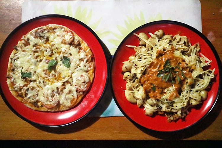 An Italian style pizza and mushroom pasta served in Kyalche