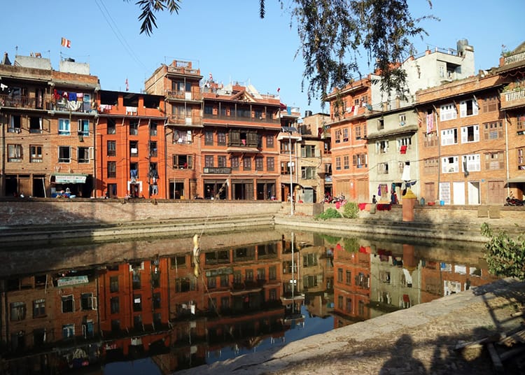 A pond in the city of Bhaktapur where the brick home reflect in the water
