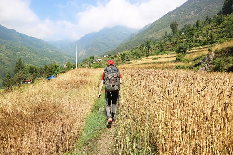 Michelle Della Giovanna from Full Time Explorer walks through a golden field in Chilingkha