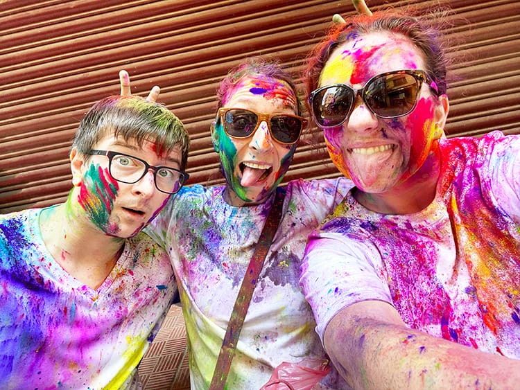 Michelle Della Giovanna from Full Time Explorer along with friends Lisi and Pat making funny faces while covered in Holi powder