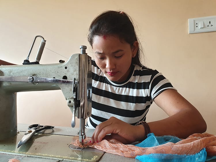 A tailor creates a new design from an old saree in Nepal
