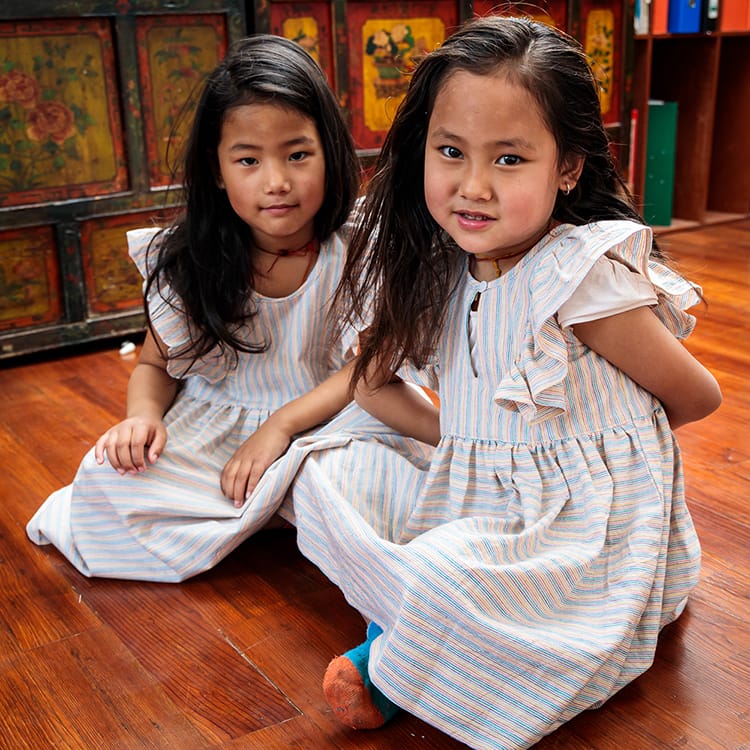 Two young girls wear Kokroma dresses