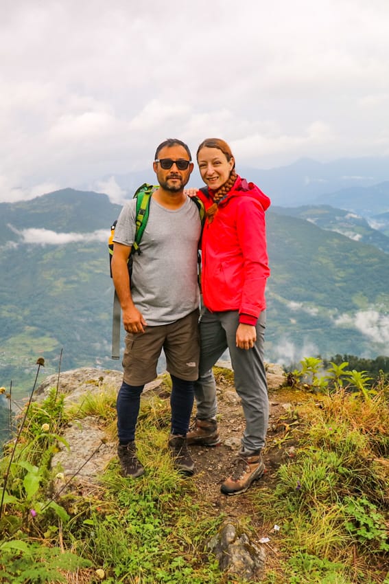 Michelle Della Giovanna from Full Time Explorer and her husband Suraj Pradhan pose for a photo in Khopra Danda overlooking the hills
