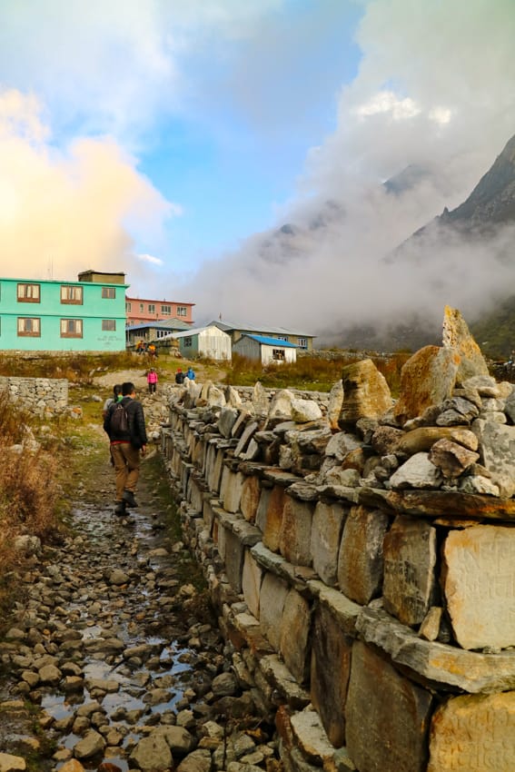 Trekkers walk past stone chortens on the way to Langtang
