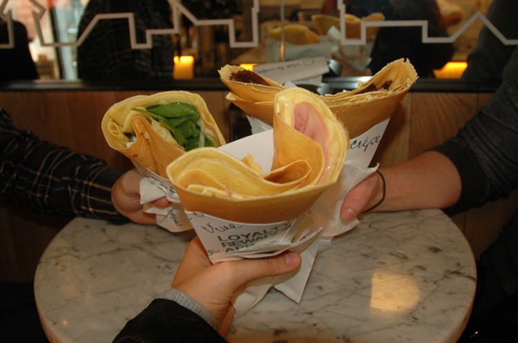 Three people hold crepes up for a phoro