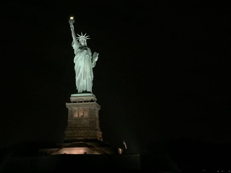 The statue of liberty illuminated at night
