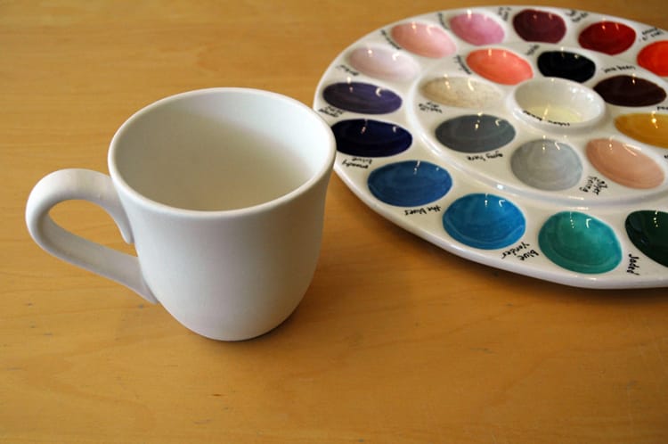 A cup waiting to be painted and a color pallet at Baked in Brooklyn 