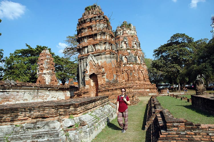 Michelle Della Giovanna from Full Time Explorer stand in front of ancient temples in Ayutthaya Thailand