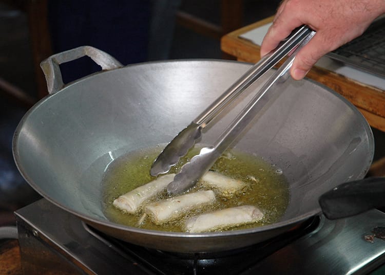 Spring rolls being fried in hot oil