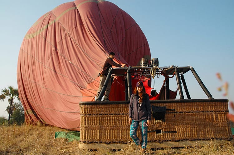 Michelle Della Giovanna from Full Time Explorer stands in front of a hot air balloon as it deflates on the ground