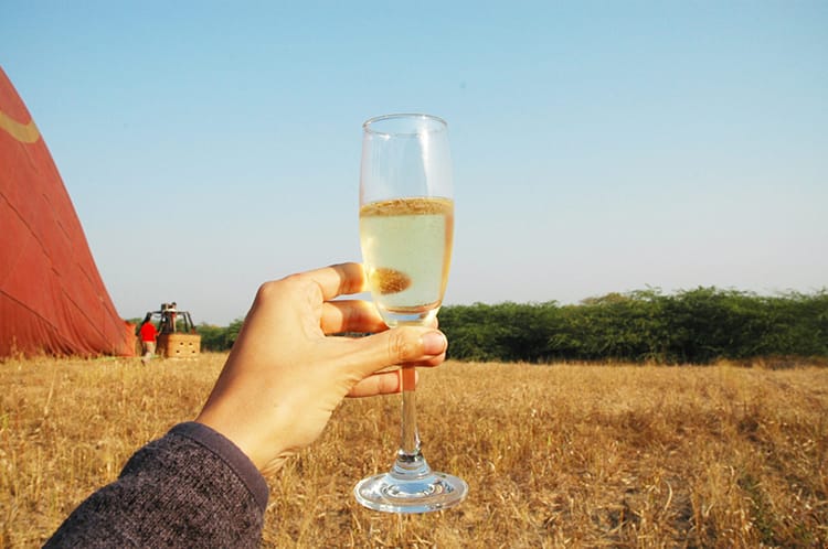 A celebratory glass of champagne in front of the field the hot air balloon landed in
