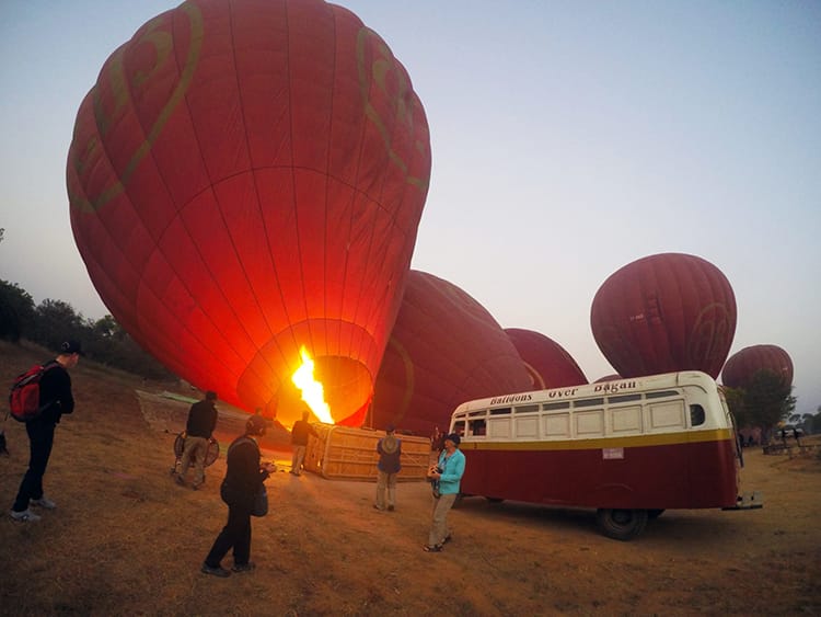 Tourists wait for hot air balloons to inflate in Bagan before boarding