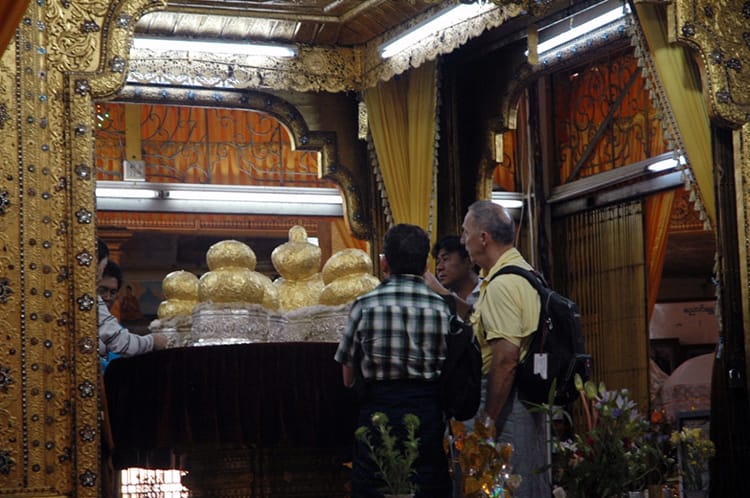 Round gold statues sit in a temple in Myanmar after being covered with gold leaf