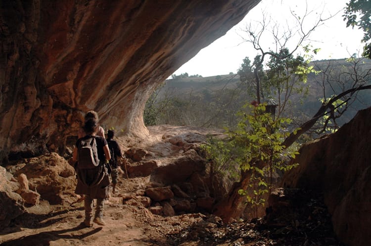 Hikers walk alongside a cave like structure on the Kalaw Trekking route