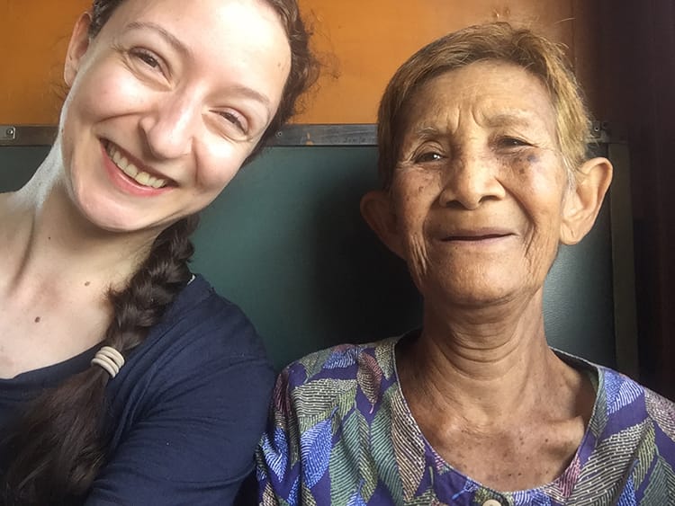 Michelle Della Giovanna from Full Time Explorer sits with a local woman on the train to Lopburi