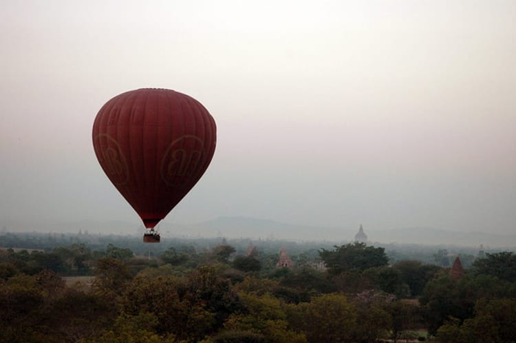 A hot air balloon flies over Bagan, Myanmar before the sun rises