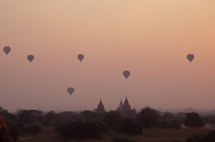 Hot air balloons fly over the temples of Bagan, Myanmar at sunrise