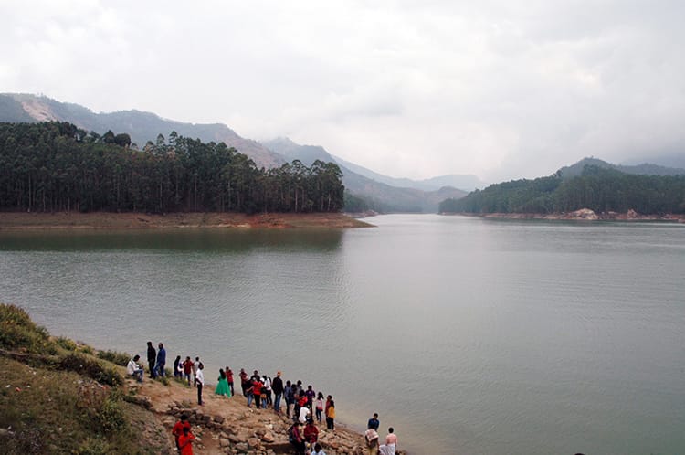 Tourists stand on the edge of Mattupetty Dam in Munnar