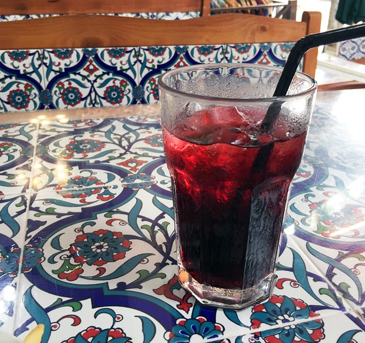 A cup of Hibiscus tea sitting on a Moroccan tile table
