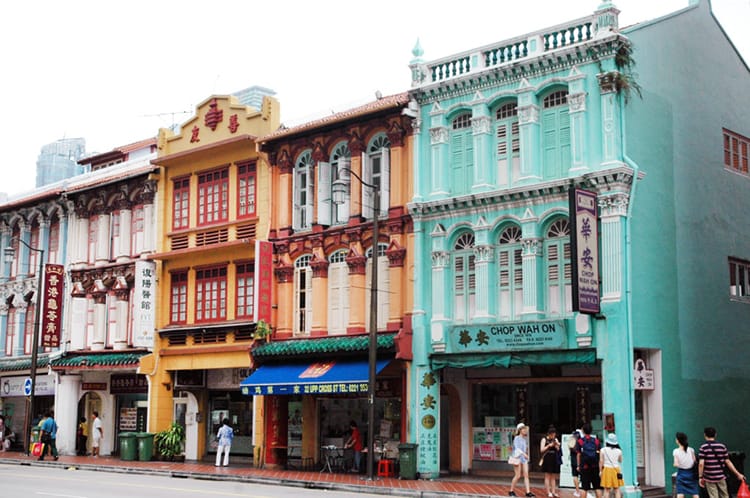 Traditional buildings painted bright colors line the street of Chinatown in Singapore