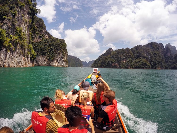 A long boat takes a group of tourists into Khao Sok