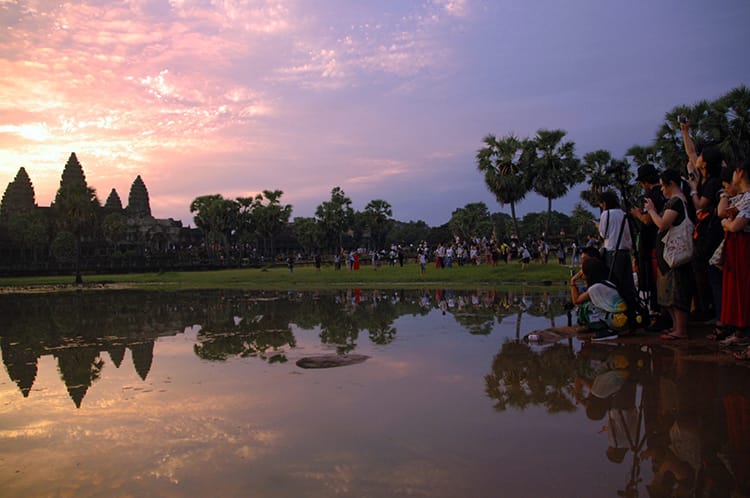 Hundreds of tourists line up to take photos of Angkor Wat at sunrise