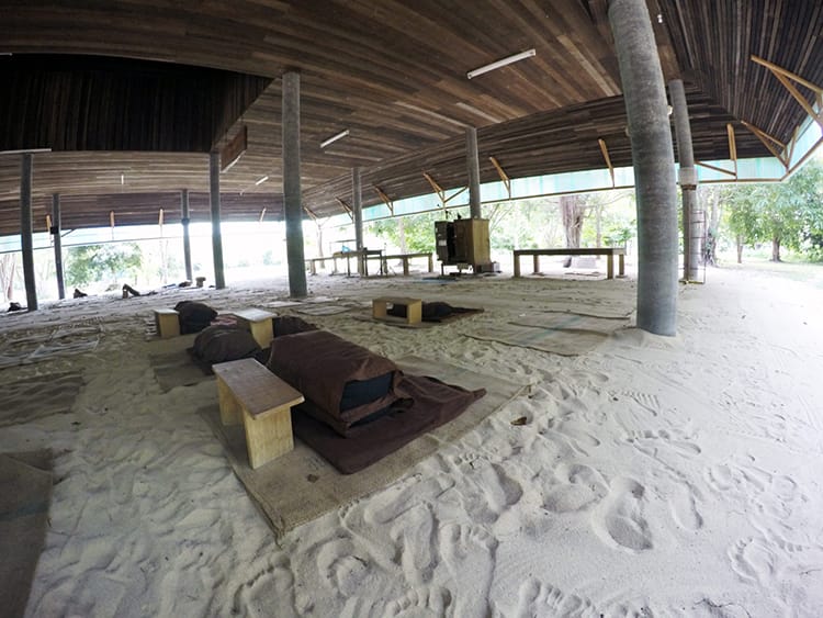 Meditation seating is set up in the sand under a pavilion in Thailand during a vipasana