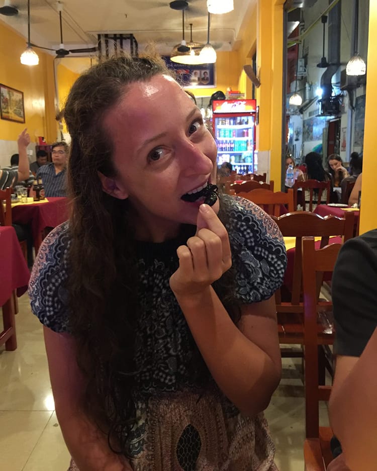 Michelle Della Giovanna from Full Time Explorer eats a scorpion in Cambodia