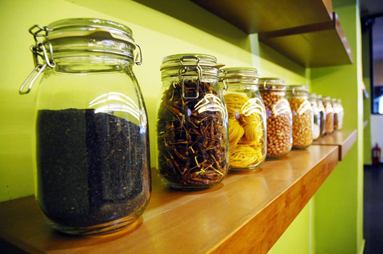 Jars holding spices and ingredients line a shelf at the cooking class studio in Phnom Penh