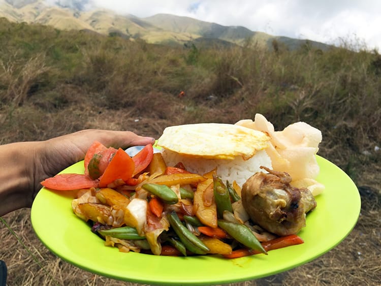 The food served along the Mount Rinajni trekking route including rice, fried chicken, and stir fried veggies