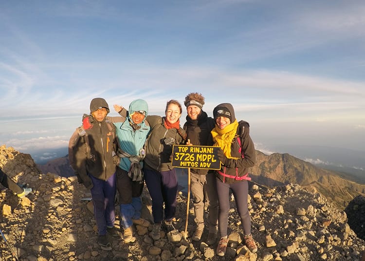 Michelle Della Giovanna from Full Time Explorer and her tour group stand on the summit of Mount Rinajni