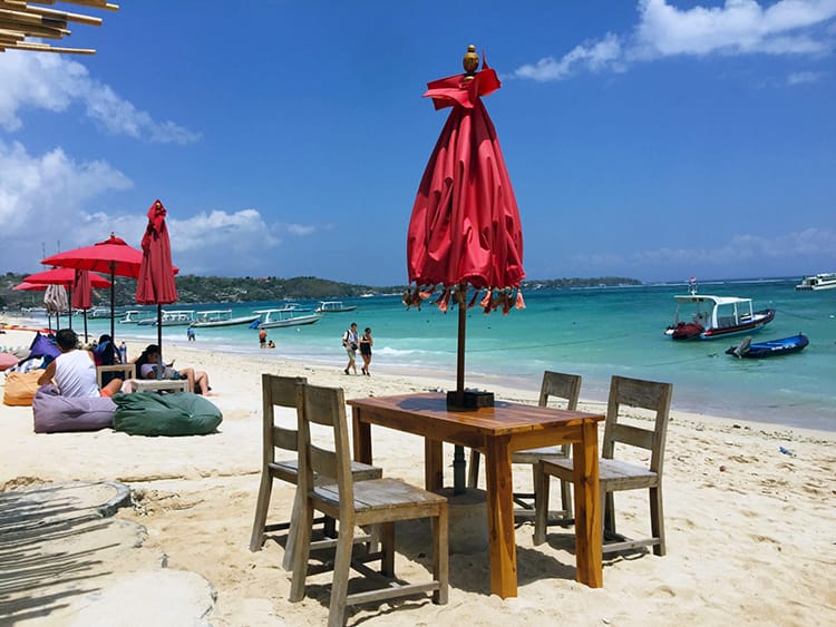 Restaurants and bean bag chairs sit on the sand on Jungat Batu Beach on Nusa Lembongan