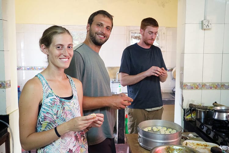 Three tourists make momos by hand in a Nepali cooking class
