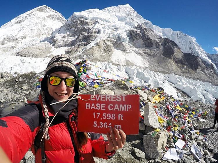 Michelle Della Giovanna from Full Time Explorer holds up a sign for Everest Base Camp